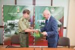 Dyrektor Izby Administracji Skarbowej wraz z Komendantem Straży Granicznej wymieniają się uściskiem dłoni. 